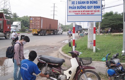 A young volunteer from Thu Duc Youth Union mends a rider’s flat tire by the highway. (Photo: SGGP) A young volunteer from Thu Duc Youth Union mends a rider’s flat tire by the highway. (Photo: SGGP)